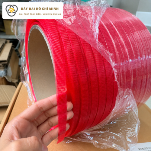 Cận cảnh dây đai PP nguyên sinh màu đỏ cho thấy bề mặt dây có vân đều, độ dày ổn định và khả năng đàn hồi tốt. Hình ảnh giúp khách hàng dễ dàng nhận biết cấu tạo và chất lượng dây đai.